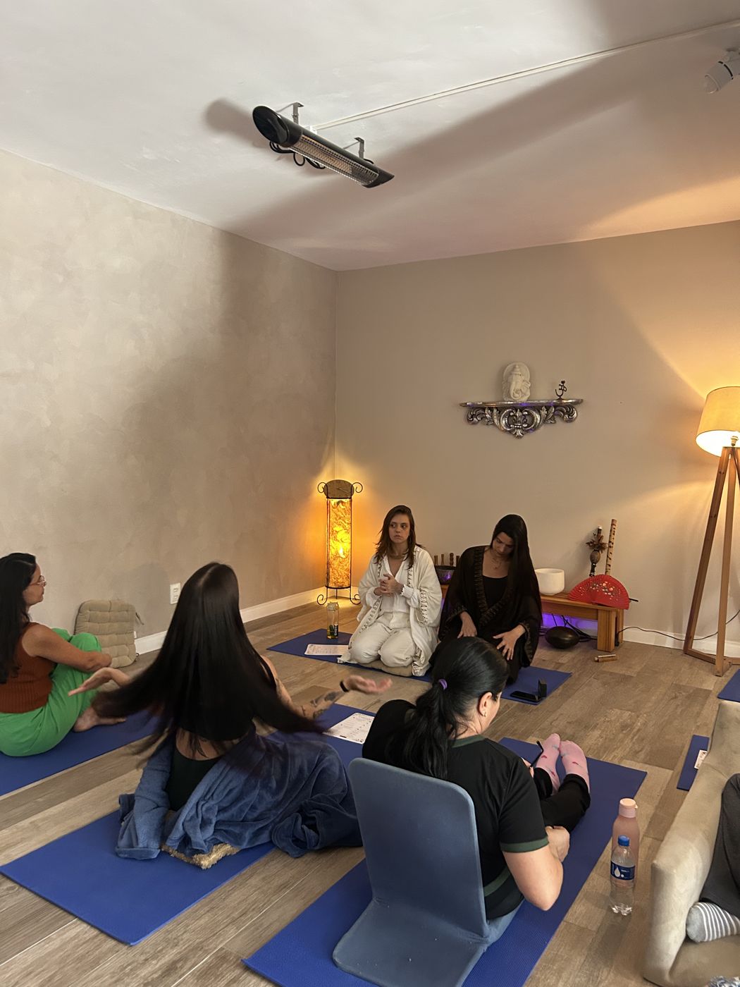 Uma aula de yoga em tapetes azuis numa sala de luz suave